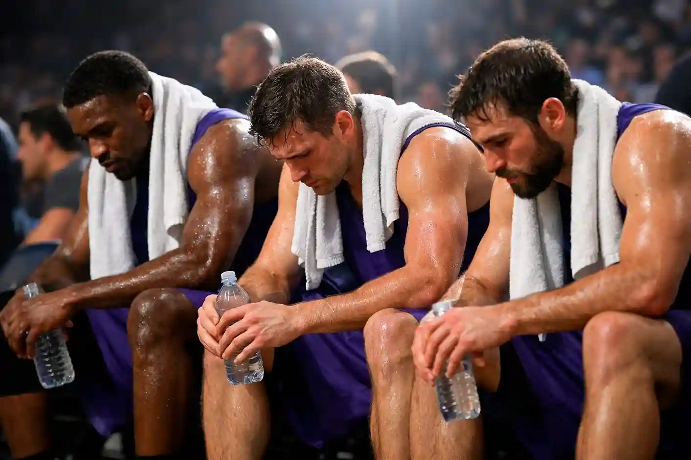 Vermoeide basketbalspelers tijdens rustmoment op de bank